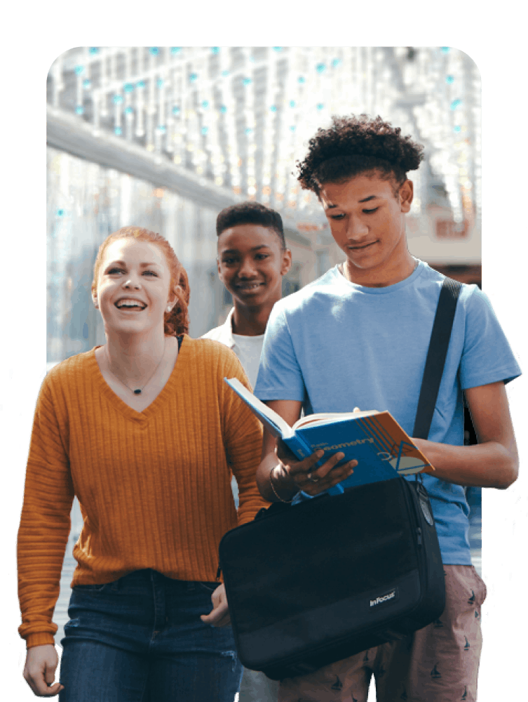 Three students walking together in a school hallway, engaged in conversation and sharing a moment of camaraderie.