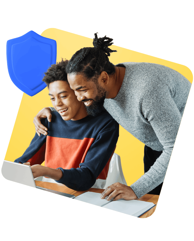 A man and a boy collaborating and discussing while looking at a laptop screen together.