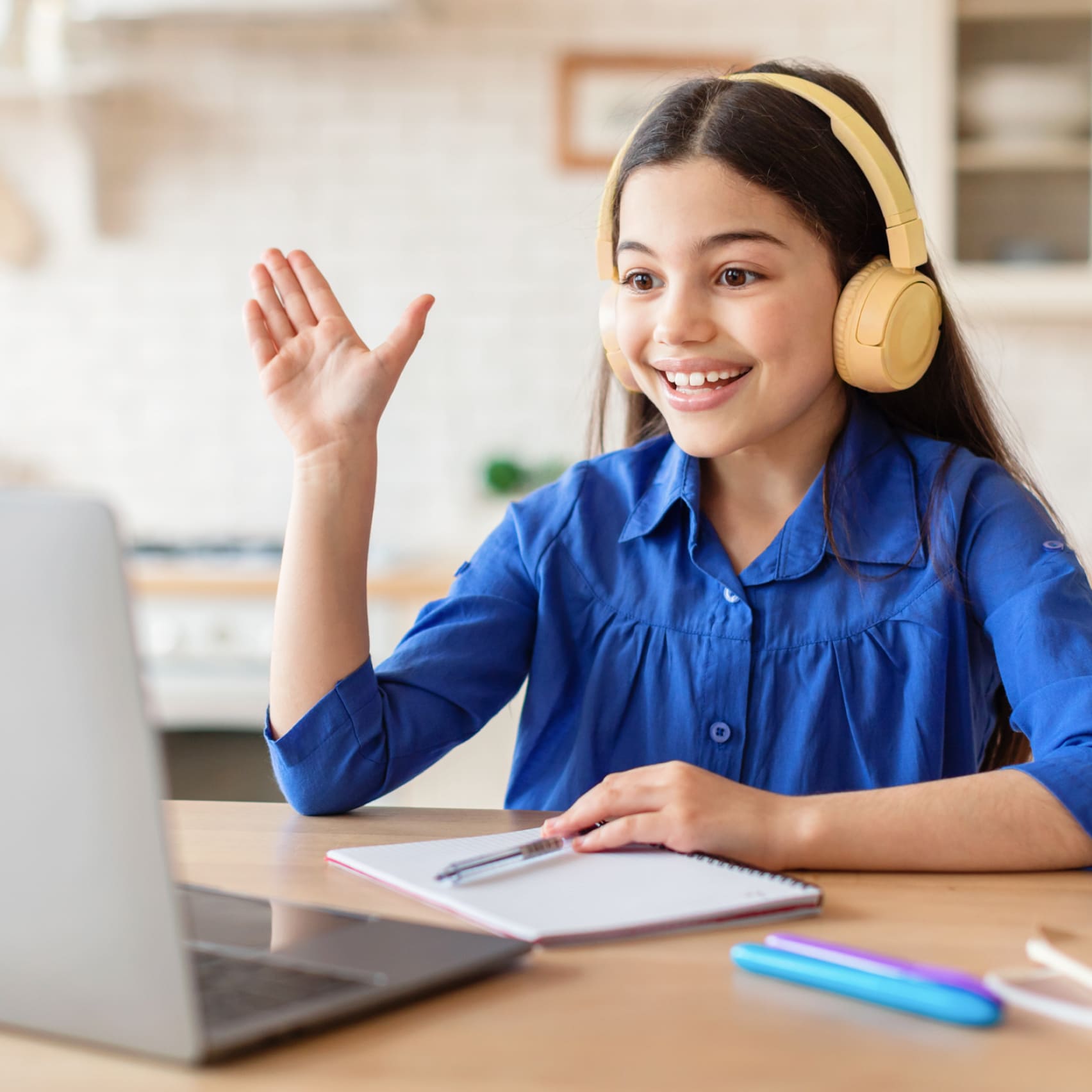 A girl wearing headphones is focused on her laptop, immersed in her work or entertainment.