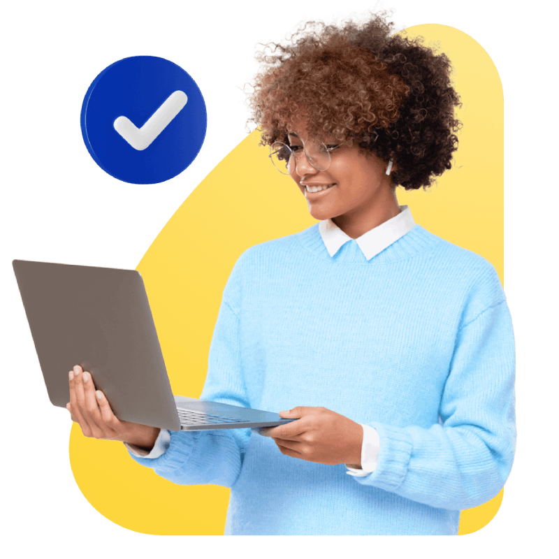 A person in a blue sweater and glasses smiles while holding a laptop. A blue checkmark icon is in the background, set against a yellow shape.
